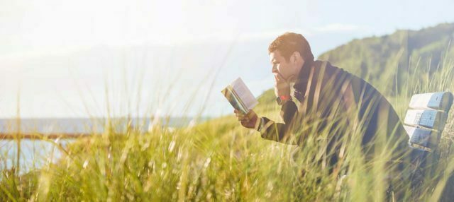 Man som läser bibeln ute i naturen