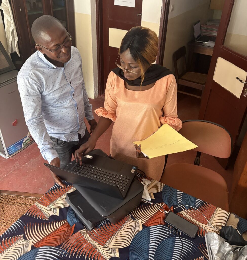 Makani och Lydie hjälps åt för att ta fram ett dokument till våra revisorer.