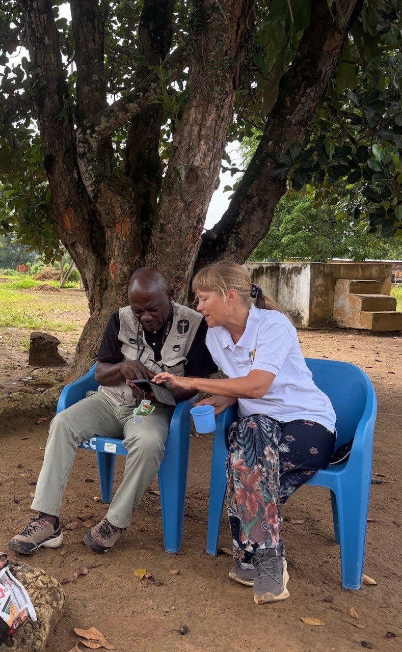Pernilla går igenom kartan i mobilen med Joseph på väg upp mot Tsimba.